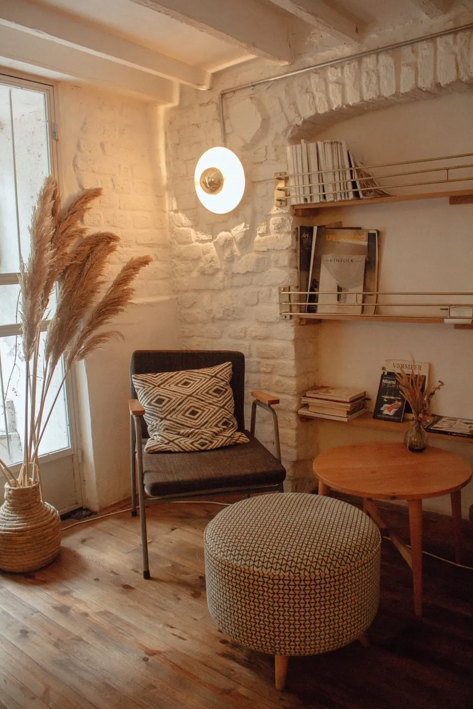 Brass candle holders and a clay bowl displayed on a woven rug